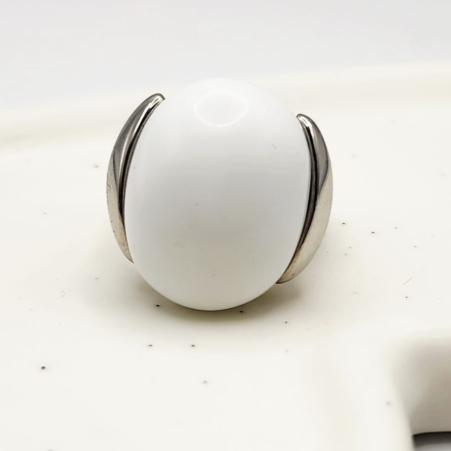 White ceramic ring with silver band on a white background