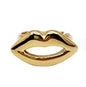 Gold lip-shaped ring on a white background